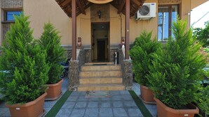 The entrance to the Marsel Hotel with a sign above the entrance, steps leading up to the door, and two potted plants on either side. - Marsel Hotel (Tbilisi)