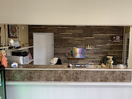 Una recepción con un fondo de pared de piedra, un cuadro enmarcado y varios objetos decorativos.