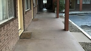Un pasaje cubierto con paredes de ladrillo y ventanas, que conduce a la entrada de un edificio.