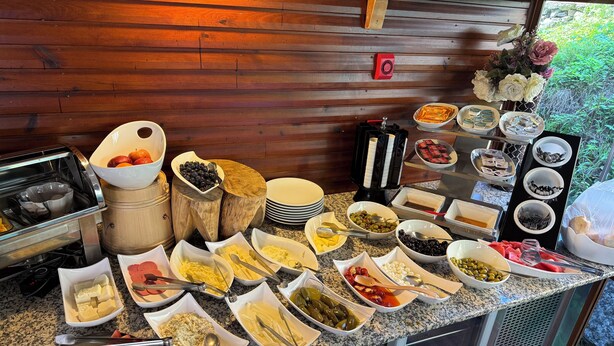 Un bufé con diversos alimentos y utensilios sobre una encimera de granito.