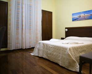 A hotel room with a bed, a wooden wardrobe, a chair, a curtain, and a painting on the wall. - Villa Albertina Exclusive B&B (Parabita)