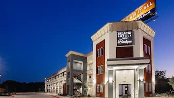 A multi-story hotel with a prominent sign for the Palacio Royale Inn Boutique.