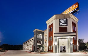 A multi-story hotel with a prominent sign for the Palacio Royale Inn Boutique. - Palacio Royale Inn Boutique Katy (Katy)