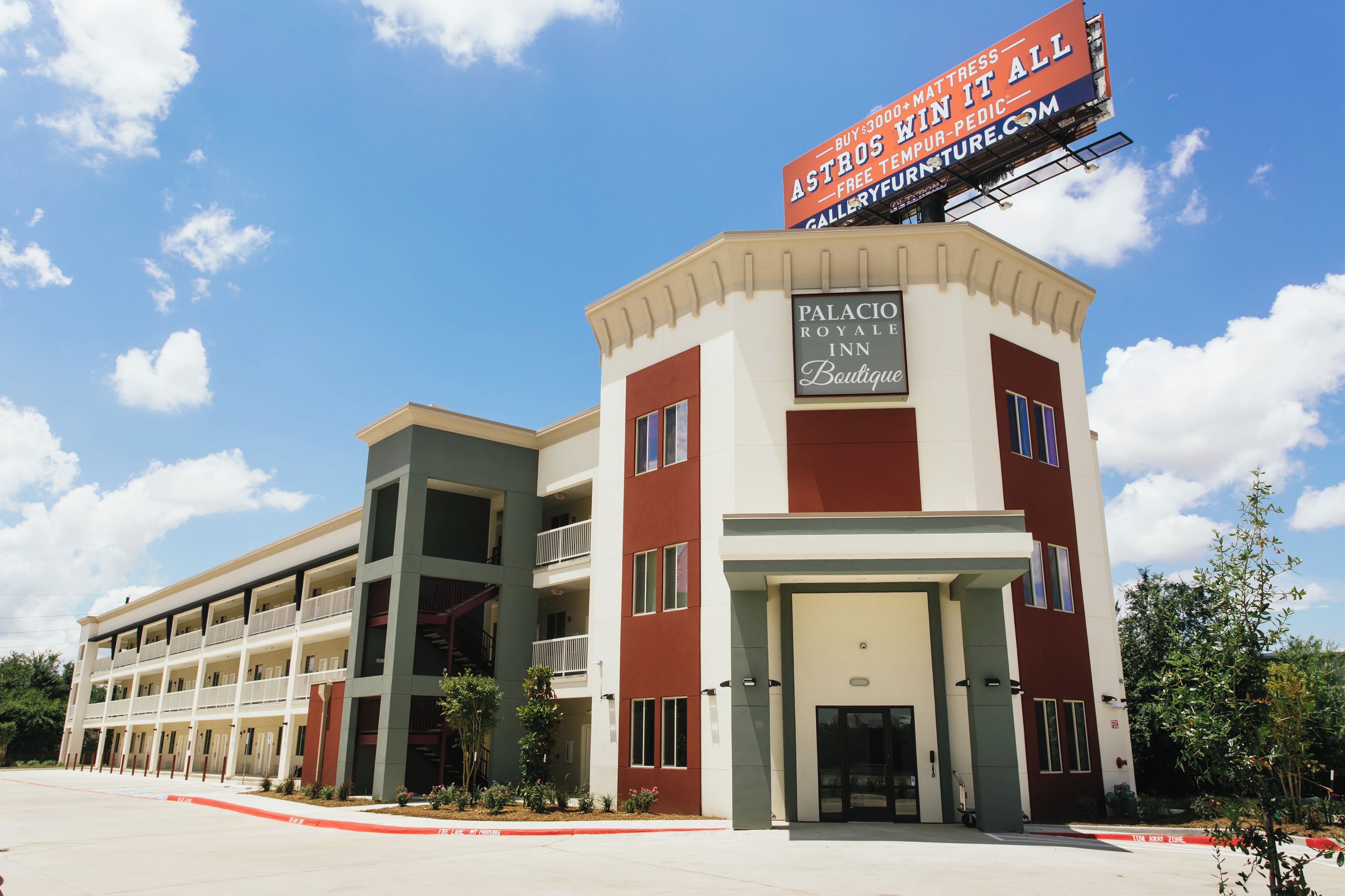 A hotel with a prominent sign advertising a mattress sale.