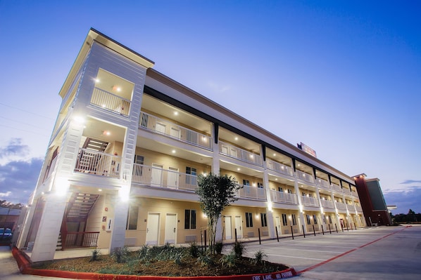 A multi-story hotel with balconies, a fire lane, and a parking lot.