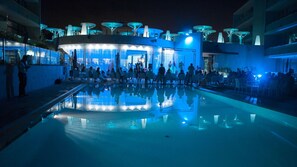 Una piscina al aire libre, sombrillas, tumbonas