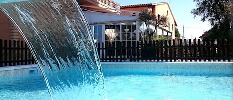 Piscine extérieure, parasols de plage, chaises longues