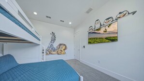 Ein Schlafzimmer mit Etagenbetten, Wandgemälde und einem großen Fenster mit Blick.