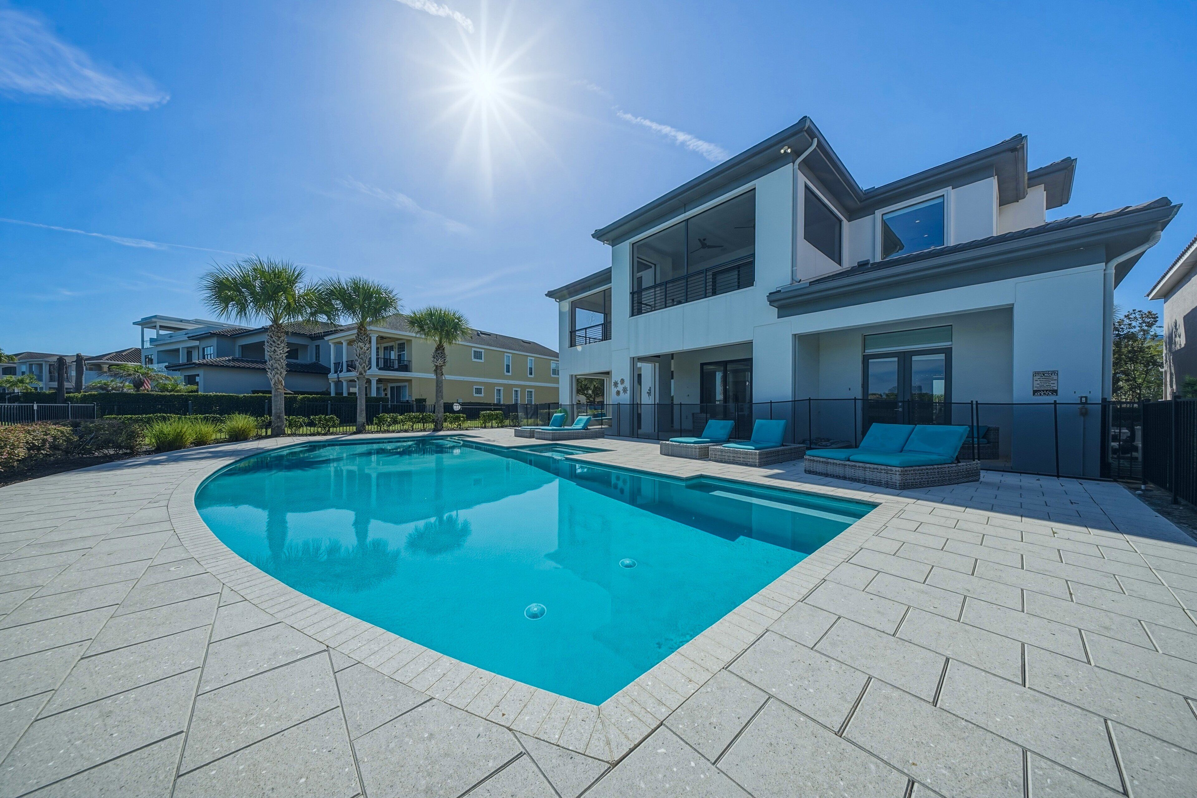 A modern two-story house with a swimming pool and outdoor seating.