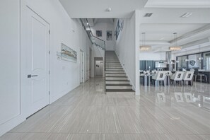 A modern interior with a staircase leading to a dining area.