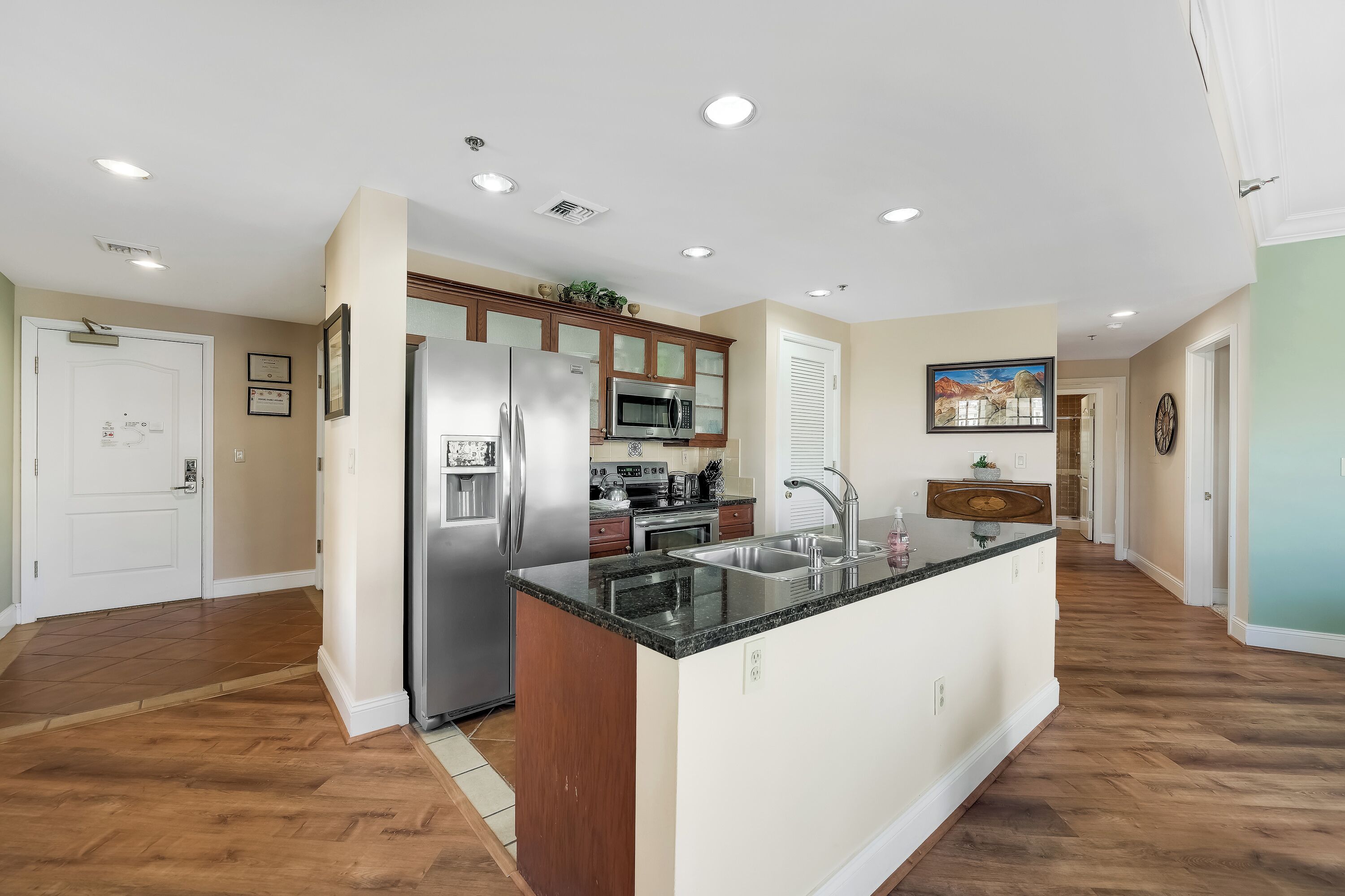 A modern kitchen with a central island, stainless steel appliances, and wooden cabinetry.