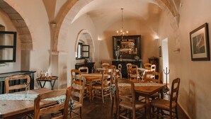 A dining area with wooden tables and chairs, a chandelier, and arched ceilings. - Meson Real de la Plata (El Marques)