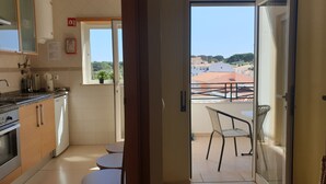 Een keuken met uitzicht op een balkon.