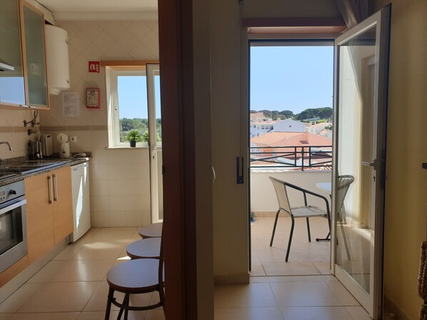 A kitchen with a view to a balcony.