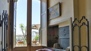 A room with two red leather chairs, a wooden cabinet, and a large window with an open door. - Castello Castriota Scanderbeg Suites De Charme (Galatina)