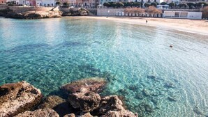 A coastal town with clear waters, rocky shoreline, and buildings along the beach. - Castello Castriota Scanderbeg Suites De Charme (Galatina)