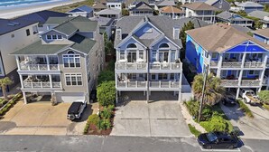 A coastal residential area with houses featuring balconies and a view of the beach.