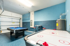 Sala de recreación con mesa de billar, mesa de hockey de aire y dispensador de agua.