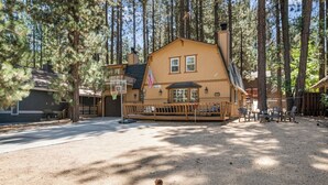 A lodge with a porch, a basketball hoop, and a flag.