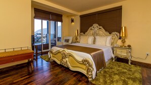 A spacious bedroom with a large bed, a nightstand, a bench, and a view of the outdoors. - The Forest and lake by Schofieldshire (Nuwara Eliya)