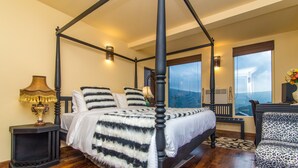 A four-poster bed with a white and black striped bedspread, a black nightstand with a lamp, and a leopard print chair. - The Forest and lake by Schofieldshire (Nuwara Eliya)