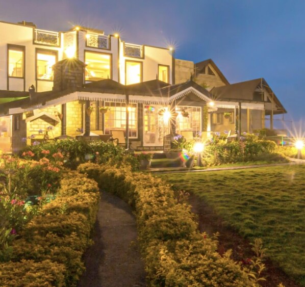 A large, multi-story house with a well-maintained garden and a pathway leading to the entrance. - The Forest and lake by Schofieldshire (Nuwara Eliya)