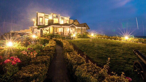 A large, modern house with a well-maintained garden and a pathway leading to the entrance. - The Forest and lake by Schofieldshire (Nuwara Eliya)