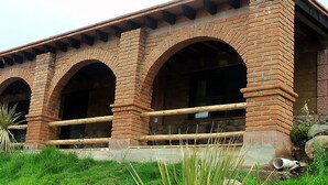 A brick building with multiple arches and a balcony.