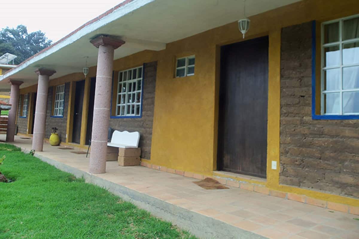 A building with a covered porch, columns, and a stone facade.