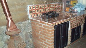 A kitchen with a tiled backsplash, a gas stove, and black cabinets.
