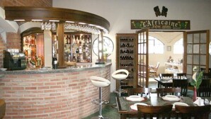 A bar area with a brick counter, bar stools, and a wine rack. - Hotel Fazenda Reviver (Araçoiaba da Serra)