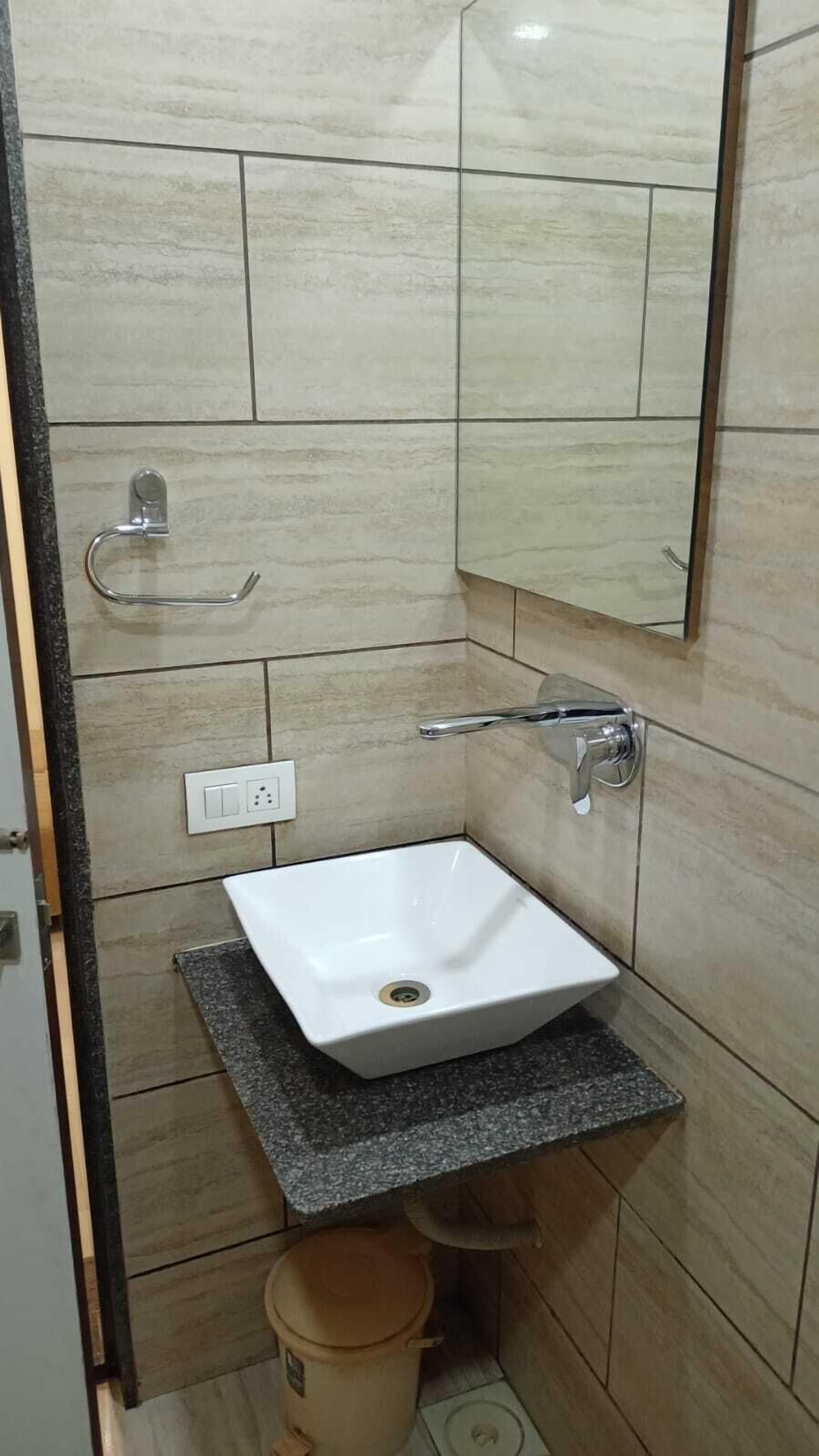 A bathroom with a white sink, a mirror, and a towel rack.