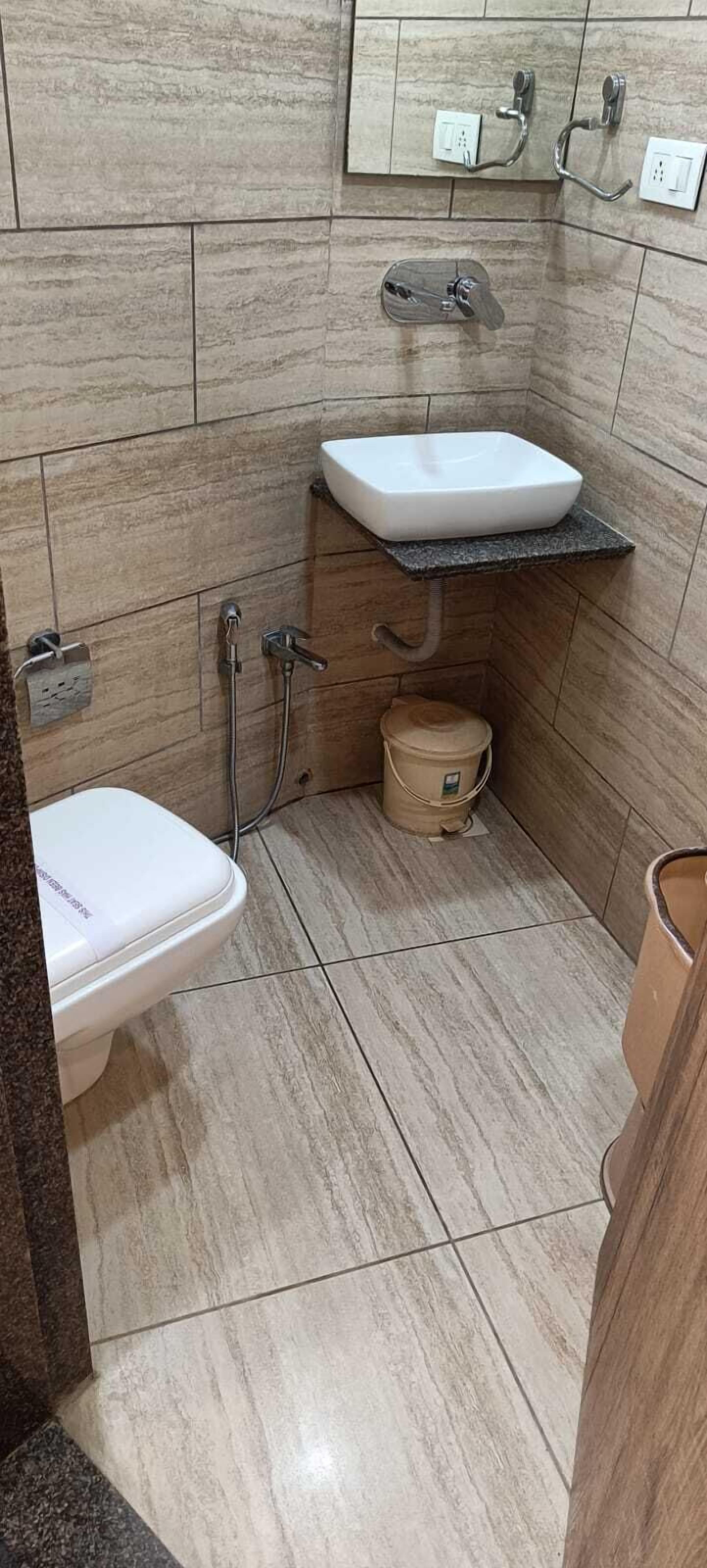 Une salle de bain avec un lavabo blanc, des toilettes et un espace douche.