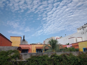 A residential area with colorful buildings, a prominent chimney, and a clear sky with clouds. - Brisas del Caribe Suite (Playa del Carmen)