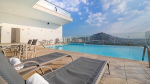 A rooftop pool area with lounge chairs, a glass balustrade, and a view of a distant mountain. - Holiday Inn Express Cartagena Manga by IHG (Cartagena)