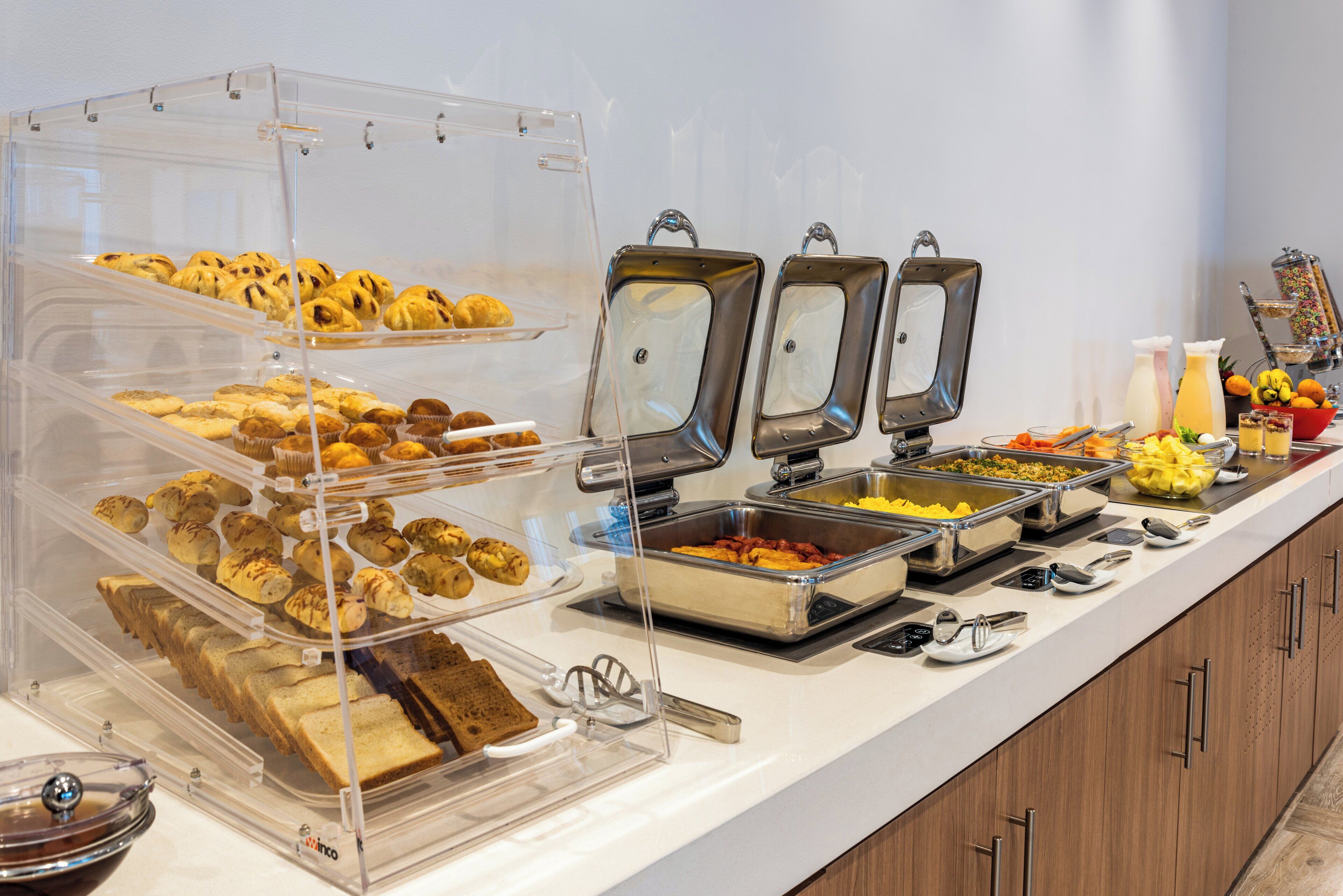 A buffet with various food items and utensils.