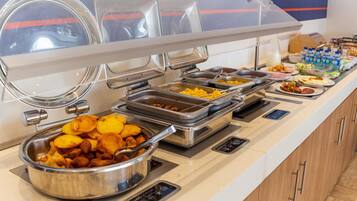 A buffet with various food items and a water dispenser.