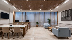 A modern conference room with a long table, chairs, a sofa, and a TV. - Holiday Inn Express Cartagena Manga by IHG (Cartagena)