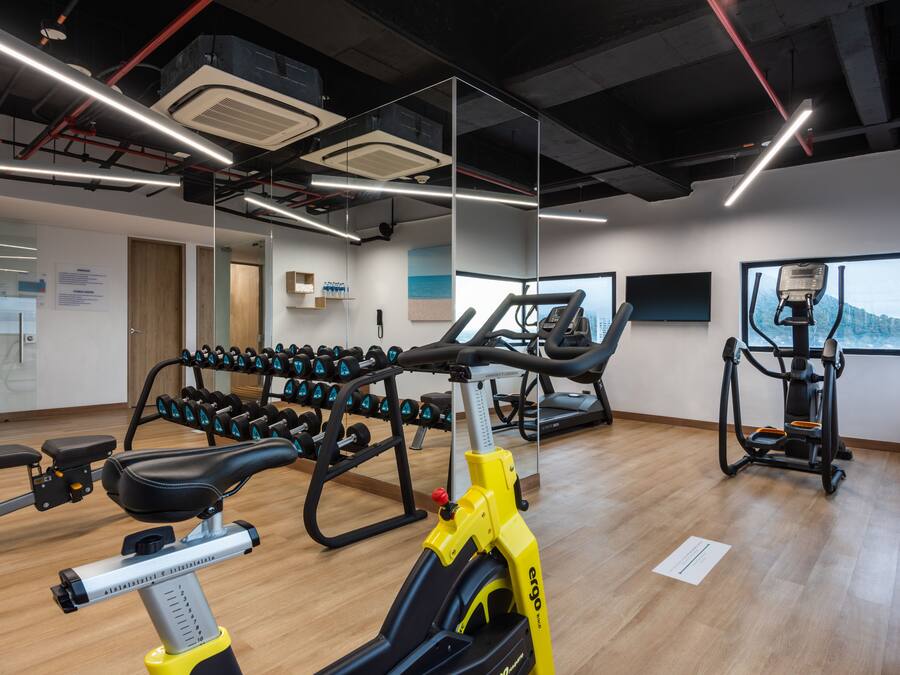 Un gimnasio con equipo de ejercicio, cinta de correr y remo.