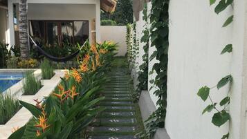 Un chemin bordé de pierres décoratives mène à un bâtiment dont le toit est recouvert de tuiles.