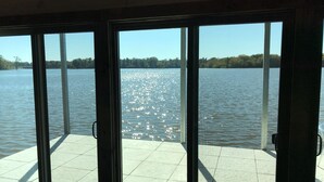 A view from inside a building looking out at a calm lake with a clear sky. - FLOATING Apartment. Enchanting Lake Views, Sunsets, FUN (Monroe)