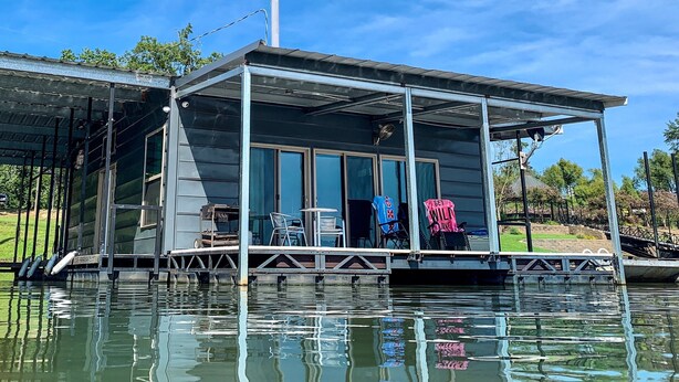 A floating house with a covered patio, large windows, and a small dock. - FLOATING Apartment. Enchanting Lake Views, Sunsets, FUN (Monroe)