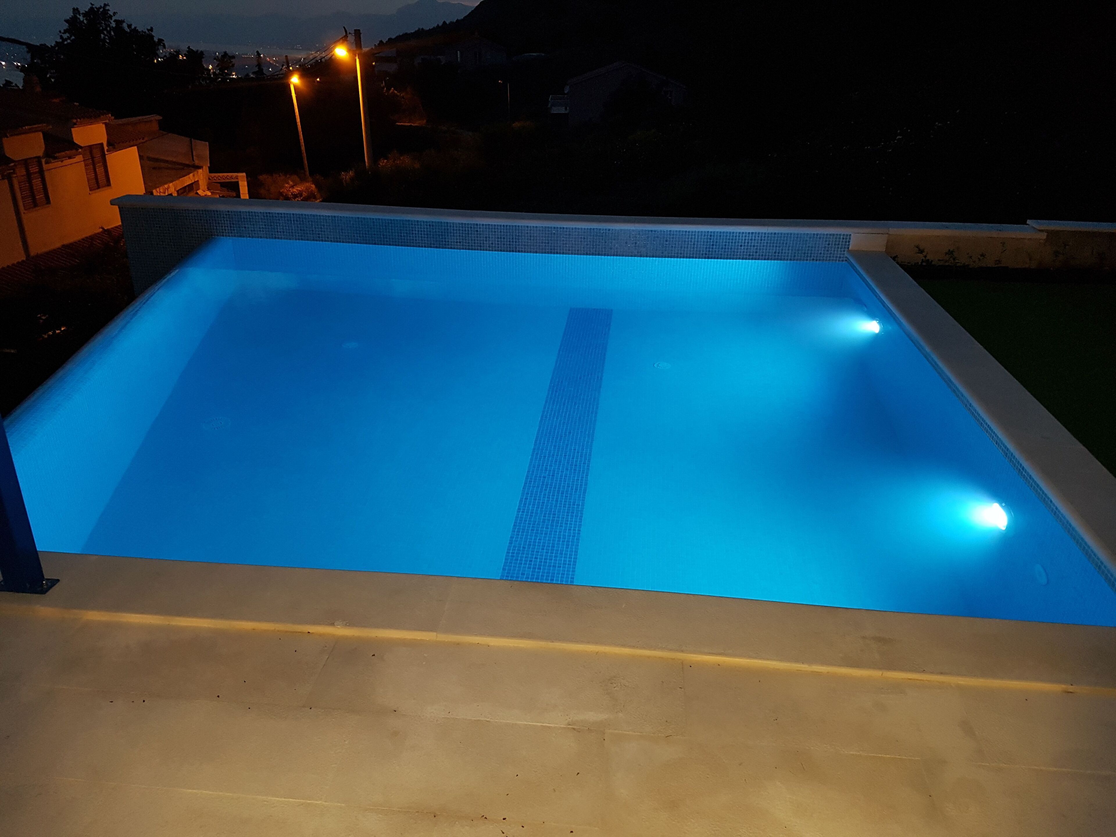 Una piscina rectangular con borde de azulejos y un separador central.