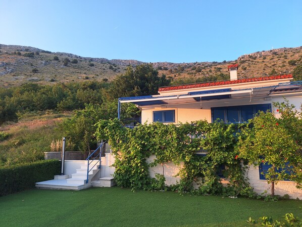 A house with a red-tiled roof, a white exterior, and a staircase leading to the entrance. - Villa Blue - spectacular view and heated pool, Split riviera, Croatia (Podstrana)