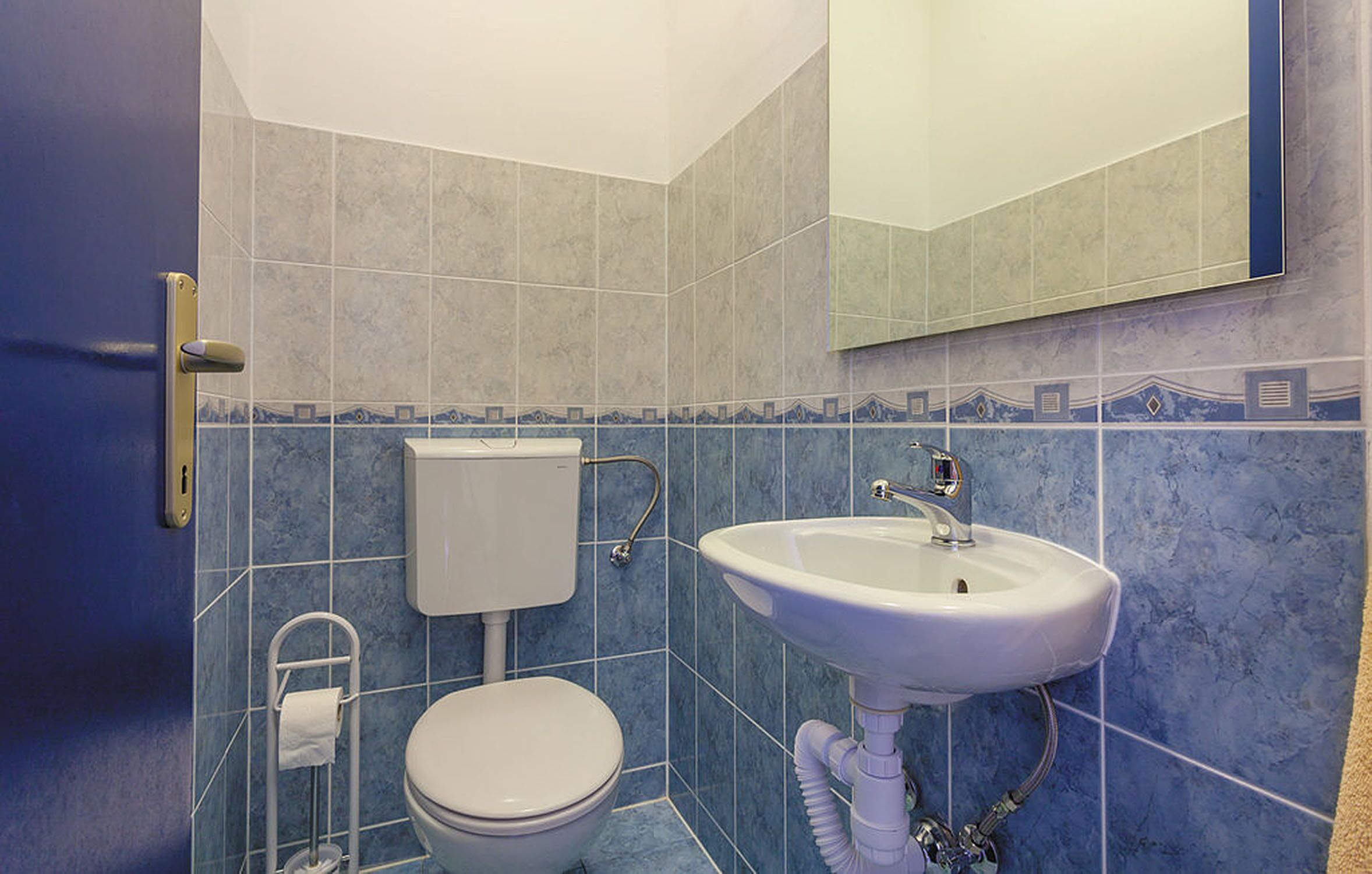 Une salle de bain avec des toilettes, un lavabo et un miroir.