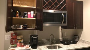 A kitchen with a built-in microwave, a coffee maker, and various coffee pods on the counter. - A Fabulous home in the Rocky Mountain State (Centennial)