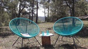 Two turquoise chairs with a small wooden table between them, set in a forested area. - In the heart of nature, a welcoming nest with swimming pool to recharge your batteries (Barjols)
