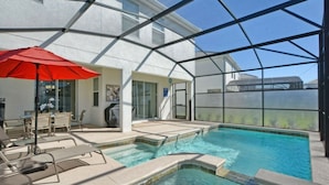 A pool area with a glass enclosure, lounge chairs, and a red umbrella. - 4712 Fabulous & Brand-New Private Pool (Kissimmee)