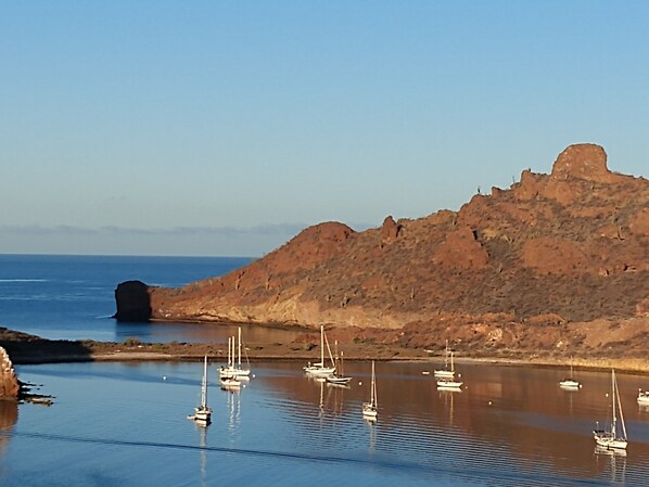 A coastal scene with boats anchored near rocky cliffs.