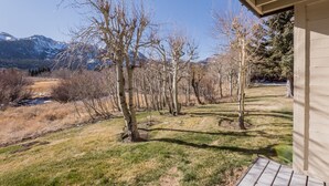 A view of a building with a wooden exterior and a grassy area in front. - Snowcreek #97 - Great Views. Large. 2 bedroom + loft, 2 bathroom, 3-level condo. Sleeps 8 (Mammoth Lakes)